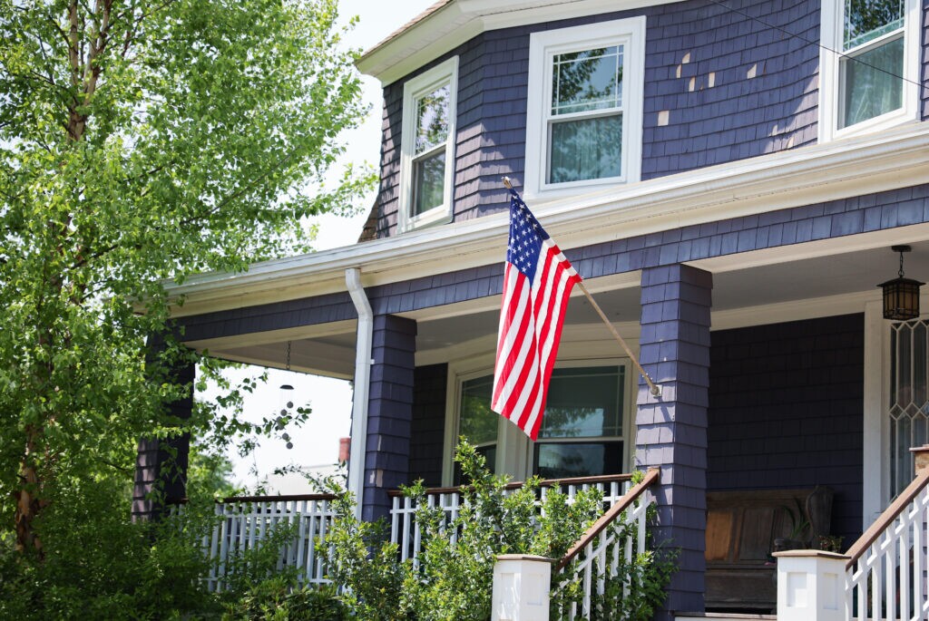 US flag proudly displayed in front of an American house symbolizes patriotism, national identity, and love for one's country. It represents unity, freedom, and the values upon which the United States