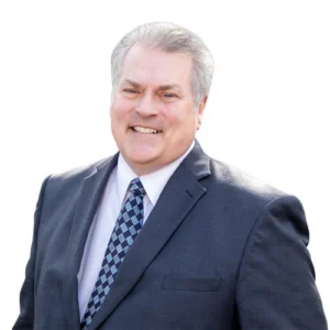 Don Hagan - WBG - 500x500 Don Hagan professional headshot wearing a gray suit, white dress shirt, and patterned blue tie against a light gray background.