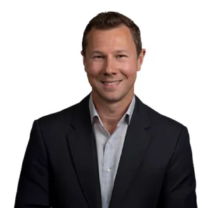 Kurt Kvamme - WBG - 500x500 Kurt Kvamme professional headshot wearing a dark business suit and light dress shirt against a light gray background.