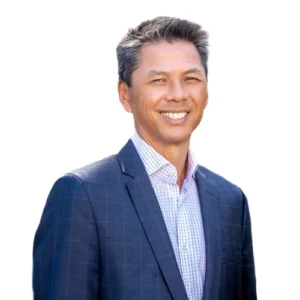 Roger Tso - WBG - 500x500 Roger Tso professional headshot wearing a navy blazer and light checkered dress shirt against a clean, neutral background.