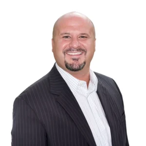 Todd Stillwagon - WBG - 500x500 Todd Stillwagon professional headshot wearing a dark pinstripe blazer and light dress shirt against a neutral background.