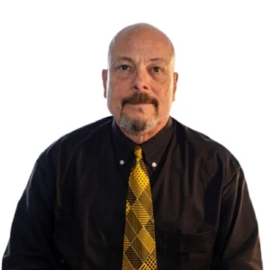 Walter Hanson - WBG - 500x500 Walter Hanson professional headshot wearing a black dress shirt and patterned gold tie against a light background.