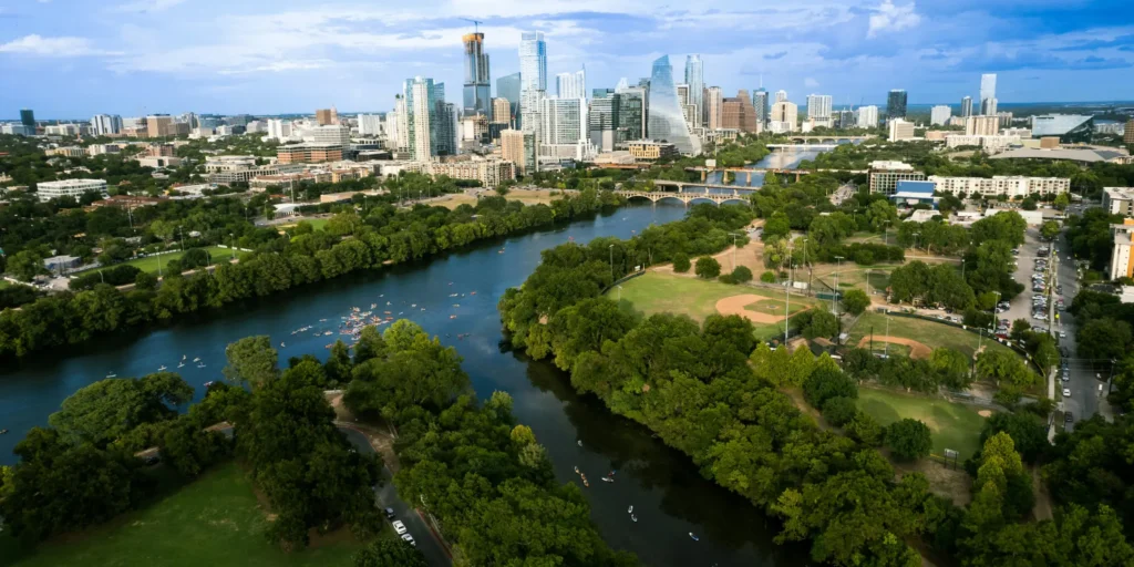 b5089517-9c93-3fef-1742-259b9e445f22 Aerial panorama of Austin, Texas, featuring the downtown skyline, Colorado River, bridges, and waterfront parks.